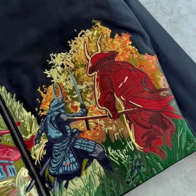 Embroidered design on a black fabric with two samurai warriors in a battle scene.