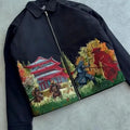 Black jacket with embroidered samurai design on a gray surface